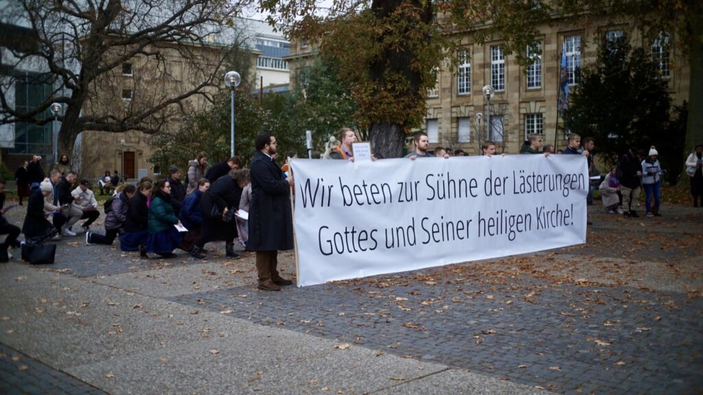Jugendliche beim Rosenkranzgebet mit Transparent vor der Staatsoper in Stuttgart